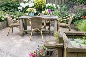 Wooden table and chairs in a ornamental garden with pond