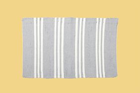 Light grey striped rug isolated on yellow background