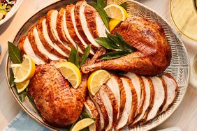 Overhead View of Smoky Maple Turkey Sliced and Served on Oval Dish with Lemon Wedges