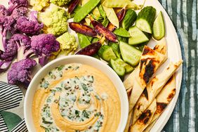 Overhead View of Spiced Lentil Dip in a White Bowl Served with Pita Bread and Vegetables for Dipping