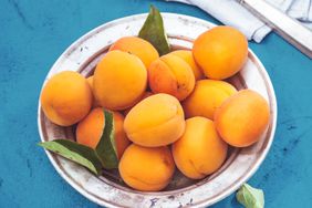 apricots in a bowl on a blue table