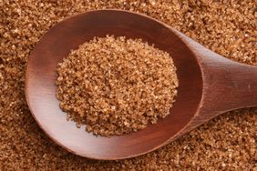 Top view of wooden spoon full of brown sugar