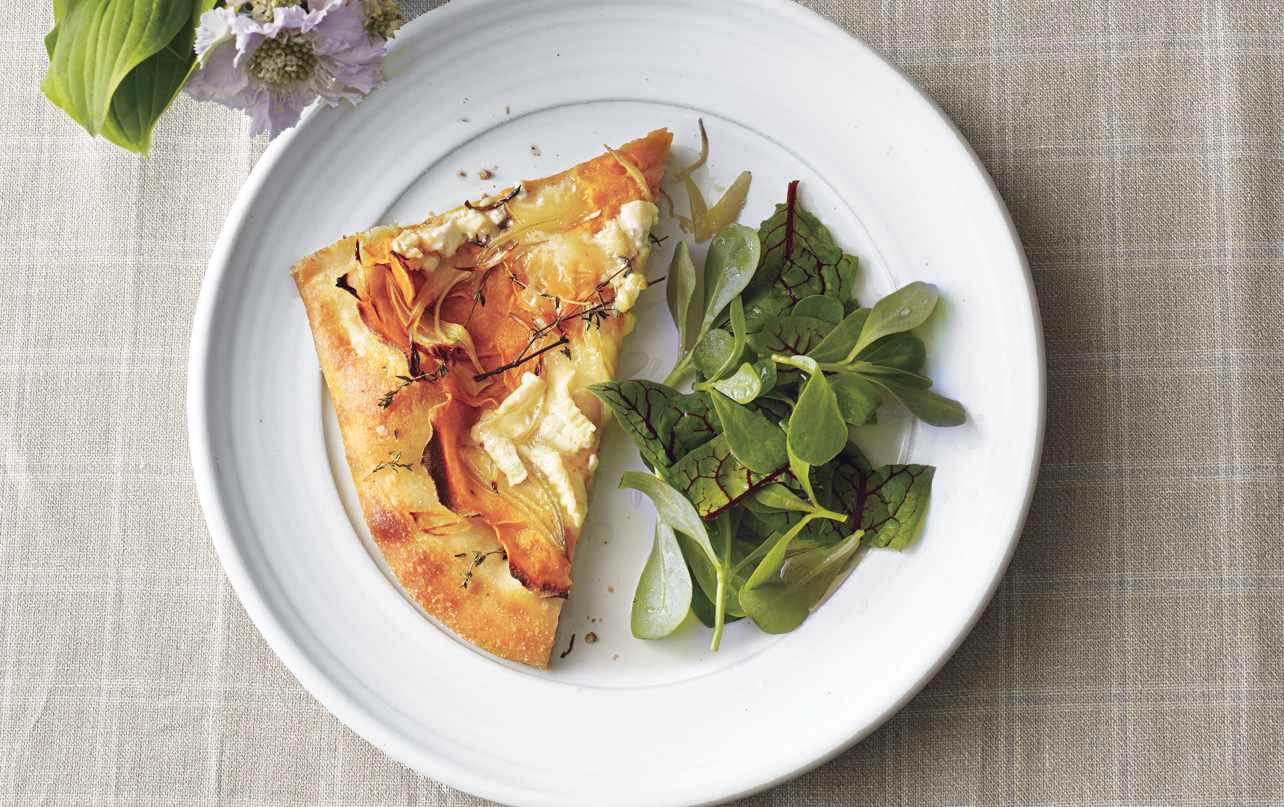 Slice of Sweet Potato and Brie Flat Bread on a White Plate With a Side of Greens