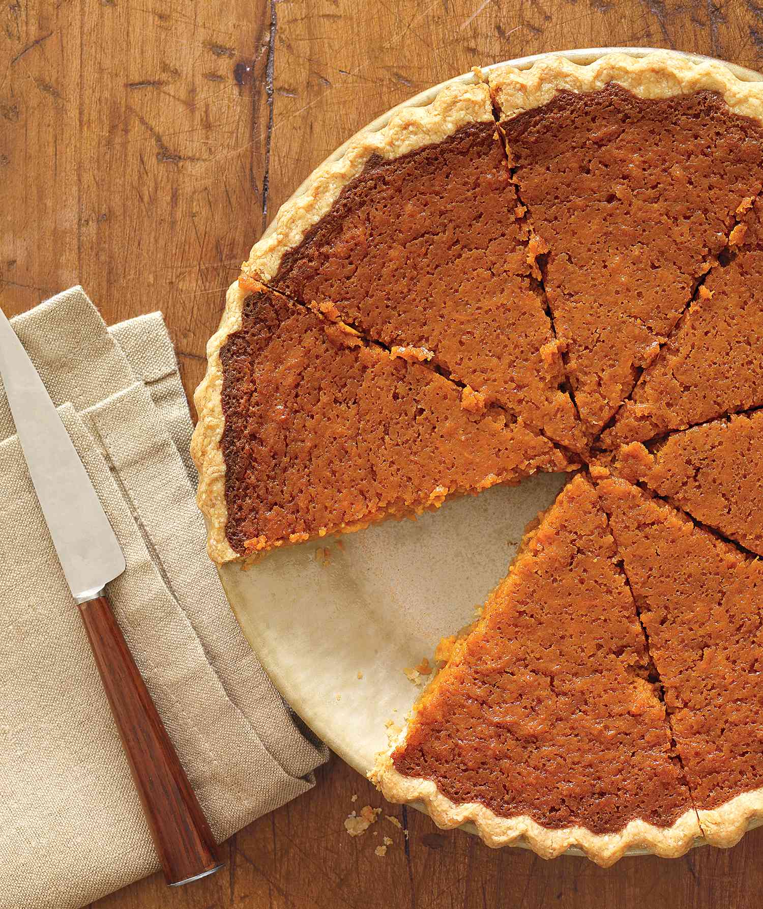 Sweet Potato Pie on a Wooden Table With a Slice Removed