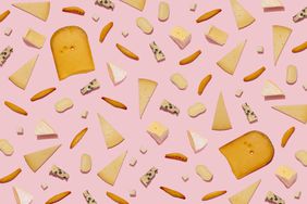 Varieties of cheese and bread sticks on pink background