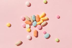 Colorful pills and capsules on pink background. Taking tablets, vitamins, painkillers, medications and dietary supplements. Minimal medical, health care, pharmacology concept. Flat lay, top view.