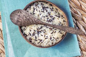 White rice and Black wild rice in a bowl with a wooden spoon