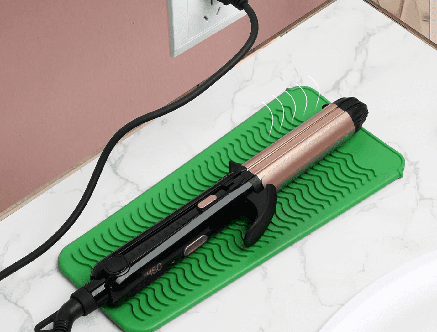 curling iron on a counter with a green heat resistant mat